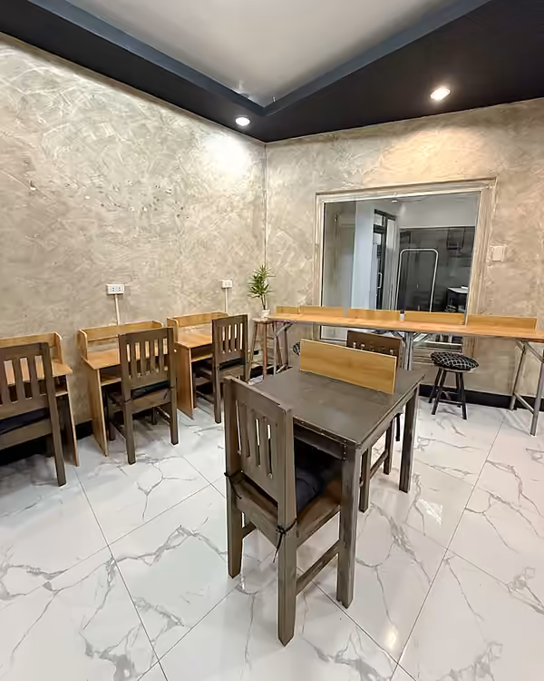 Corner of the space with study desks along the wall and a two-seat table