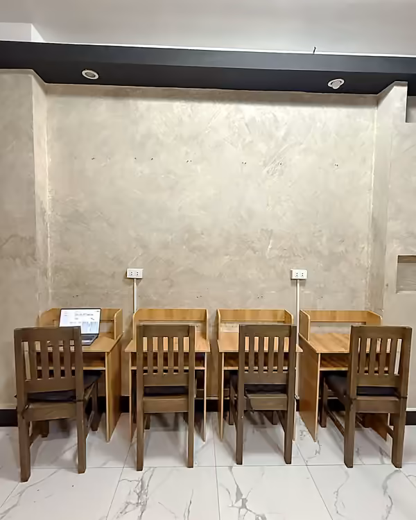 Row of four individual study desks with side dividers and wall outlets